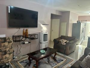 a living room with a couch and a tv on the wall at Grace in Spanish Town