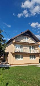 a yellow building with a balcony on the side of it at Villa Oaza Vilenjak in Visoko