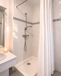 a bathroom with a shower with a shower curtain at L Echappee Jardin prive proche plage Sainte Cecile in Camiers +3 photos