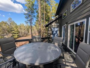 a table on the deck of a tiny house at Pinetop Getaway w Sunset Deck & Fire Pit Table in Pinetop-Lakeside