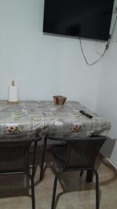 a table with two chairs and a television on a wall at Depto in Navarro +6 photos