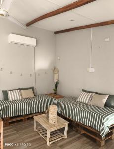 two beds in a room with a table at Quincho El Solar in Corrientes +23 photos