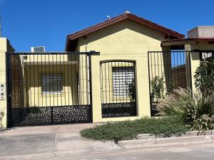 a house with a black gate in front of it at Entre Montañas in Rivadavia