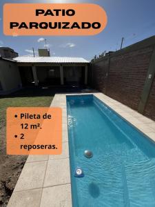 a swimming pool with a sign in front of a house at Entre Montañas in Rivadavia