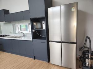 a kitchen with a stainless steel refrigerator and a sink at 비우리게스트하우스 in Kujŏm +12 photos