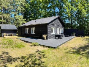 a small cabin with a deck in a yard at 4 person holiday home in Læsø-By Traum in Læsø
