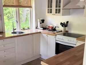 a kitchen with white cabinets and a sink and a stove at 4 person holiday home in Læsø-By Traum in Læsø