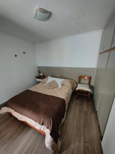 a bedroom with a large bed and a chair at Aloha in Chacabuco