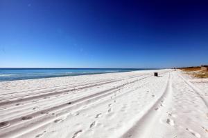 una playa con huellas en la arena y el océano en Beachside West Townhome, en Panama City Beach