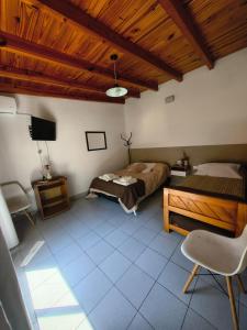 a bedroom with a bed and a wooden ceiling at Aloha in Chacabuco