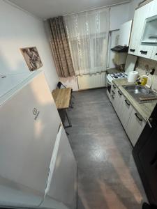 a kitchen with a white refrigerator and a table at HomeStars16 in Bîrlad