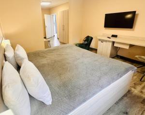 a bedroom with a large bed with a desk and a television at Le Petit - Ihre Pension in Essen in Essen