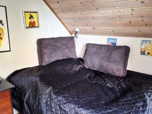 a bed with a black comforter in a bedroom at 4 person holiday home in Odder in Odder