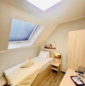 a small bedroom with a bed with a window at Le Petit - Ihre Pension in Essen in Essen