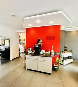 a bar with a red wall in a room at Le Petit - Ihre Pension in Essen in Essen