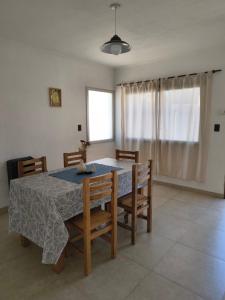 a dining room with a table and chairs and a window at Aloha 2 in Chacabuco