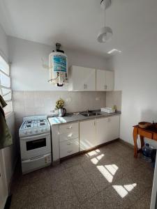 a kitchen with white cabinets and a stove top oven at DepartamentoJAP in Venado Tuerto