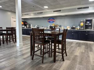 a restaurant with a table and chairs and a counter at Baymont by Wyndham Montgomery AL in Montgomery