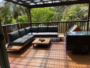 a couch and coffee table on a deck at Fernside Tranquil Retreat in Pauanui