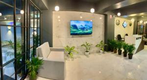 a lobby with plants and a tv on a wall at Shanti Regency in Guwahati