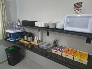a counter with some food and a microwave on it at Hotel Pousadas Club Smart in Sorocaba