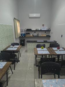 a dining room with tables and chairs and a kitchen at Hotel Pousadas Club Smart in Sorocaba +23 photos
