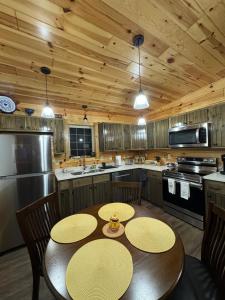 a kitchen with two tables and a kitchen with wooden ceilings at Hedgehog Hill Cabin-Helen Hideaway in Clarkesville
