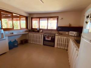 a kitchen with a stove and some windows at Varanda do Mar Caraíva Oceanfront in Porto Seguro