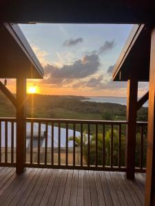 a view of the ocean from a deck at sunset at Sukha Lodge in Le Moule