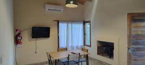 a room with a table and a television and a table and chairs at Luna Cautiva in Cafayate