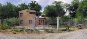 a house behind a fence with a gate at Luna Cautiva in Cafayate