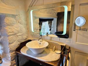 a bathroom with a sink and a large mirror at The Oxenham Arms Hotel Devon in South Zeal +137 photos