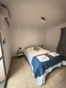 a bedroom with a bed with a blue blanket at Aloha 2 in Chacabuco