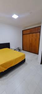a bedroom with a yellow bed and a wooden door at Apartment for 2 people - Jorge One in Adrogue