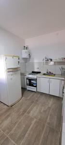 a kitchen with white cabinets and a stove and refrigerator at Apartment for 2 people - Jorge One in Adrogue