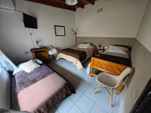 a bedroom with two beds and a desk and a chair at Aloha in Chacabuco