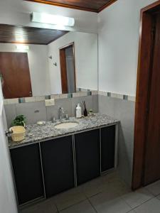 a bathroom with a sink and a mirror at Aloha in Chacabuco +5 photos
