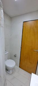 a bathroom with a toilet and a wooden door at Apartament for 2 people - Jorge Two in Adrogue