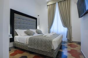 a bedroom with a bed with a large headboard at Maison 900 in Tivoli