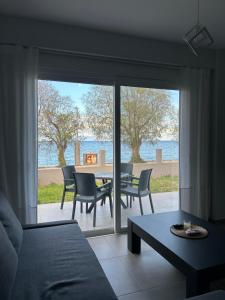 a living room with a view of a table and chairs at Serene beach house in Diakopto
