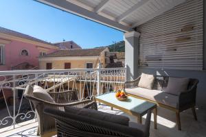 a balcony with a table and chairs on a balcony at Paxos In Square Studio Poseidon in Gaios