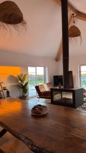 a living room with a wooden table and a fireplace at Quinta Maria Cotovia in Porto Covo