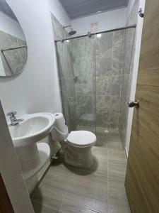 a bathroom with a toilet and a sink and a shower at Tierra Dulce - Casa Turística in Villeta +18 photos