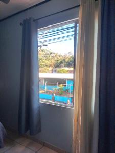 a window in a room with a view of a pool at Quepos Explorers Hub Spacious Apartment in Quepos