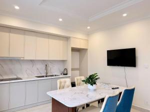 a kitchen with a table and a tv on a wall at Na homes coffee in Binh Hai