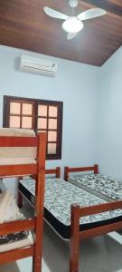 two beds in a room with a ceiling at Condominio Morada da Praia in Bertioga +19 photos