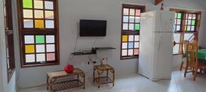 a kitchen with a refrigerator and a table and chairs at Condominio Morada da Praia in Bertioga
