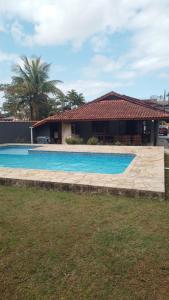 a swimming pool in front of a house at Condominio Morada da Praia in Bertioga