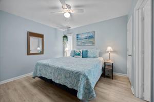 a bedroom with a bed and a ceiling fan at Tranquility By The Sea-Oceanside Condo in Salter Path +35 photos