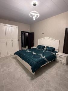 a bedroom with a large bed with a green comforter at Suf Hills Cabin in Jerash
